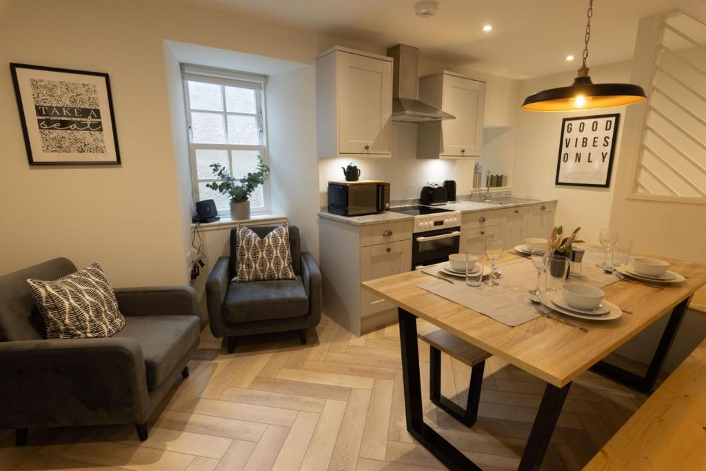 a living room with a table and a kitchen at Harbourside, Shetland Islands in Lerwick