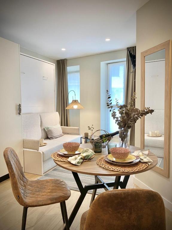 a living room with a table and chairs and a couch at ALTZOAN Apartamentos Turísticos y aparcamiento gratuito in Zarautz