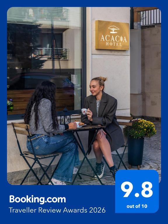 two women sitting at a table in front of a restaurant at Acacia Boutique Hotel in Sofia