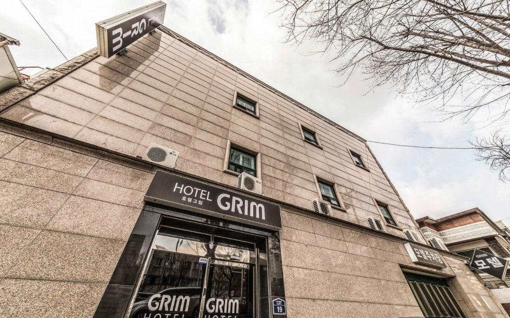 a building with a sign on top of it at Dapsimni Hotel Grim in Seoul