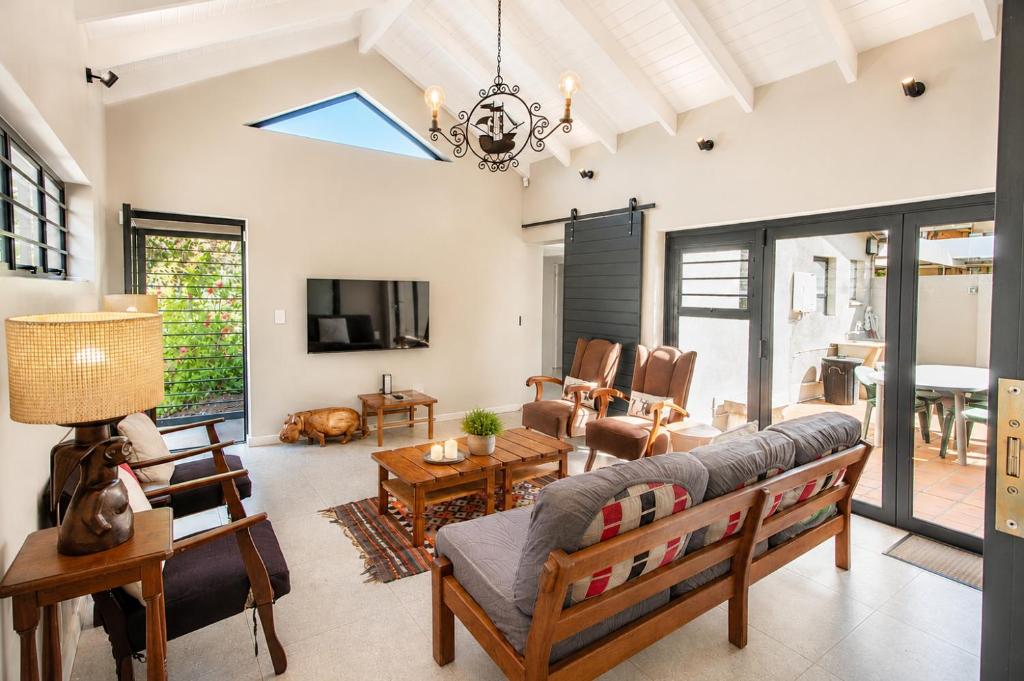 a living room with a couch and a tv at Sandy Fingers Apartment in Plettenberg Bay