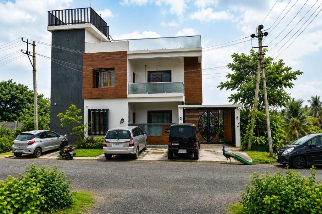 a house with cars parked in front of it at Dsouza Stay in Mysore