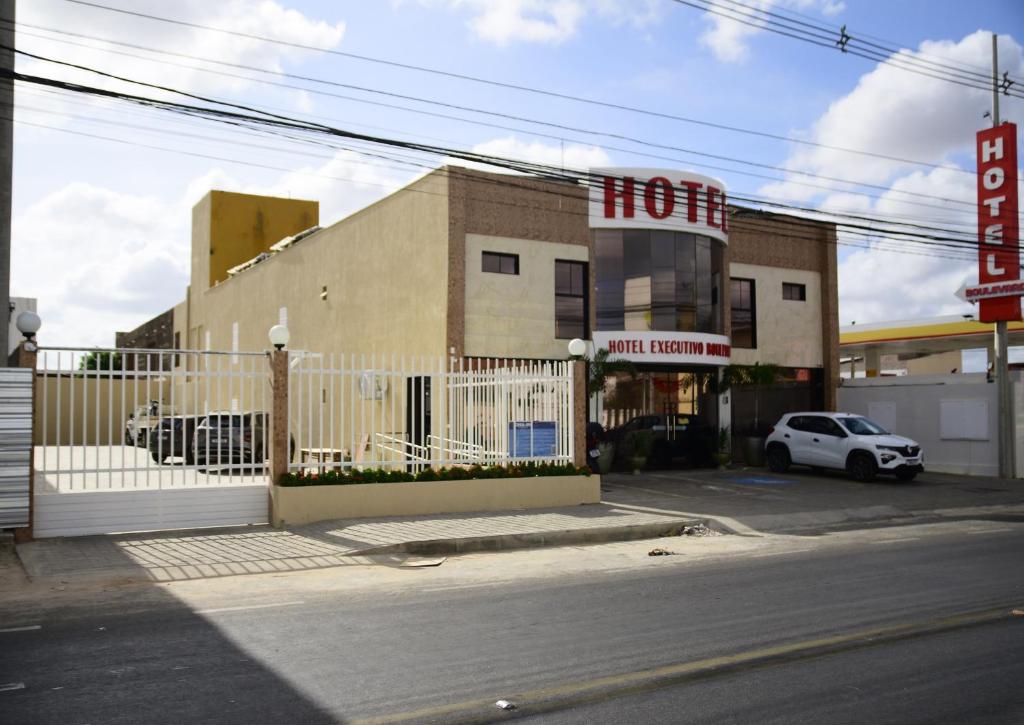 Ein weißes Auto parkt vor einem Hotel. in der Unterkunft Hotel Executivo Boulevard in Mossoró