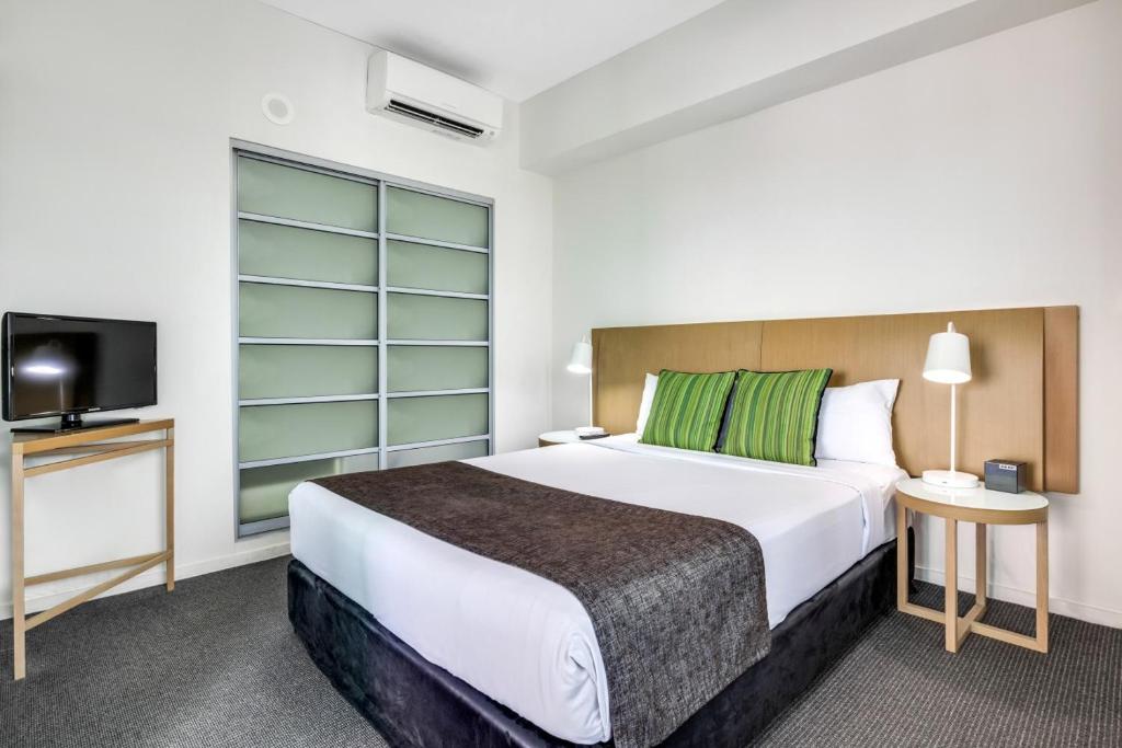 a hotel room with a bed and a tv at 18th Floor Seaview Executive Style King Bed with Pool and Gym in Darwin