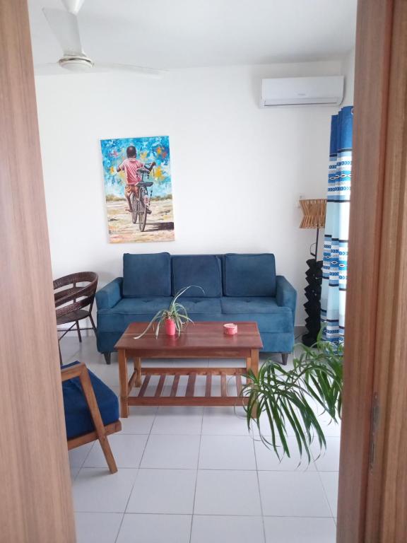 a living room with a blue couch and a table at Fumbatown's Finest in Mchamba Wima
