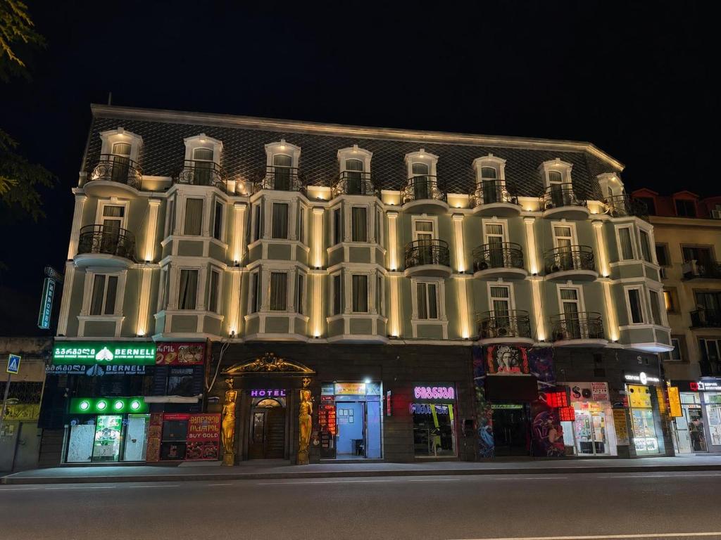 a large white building with lights on it at night at Fortuna Hotel in Batumi