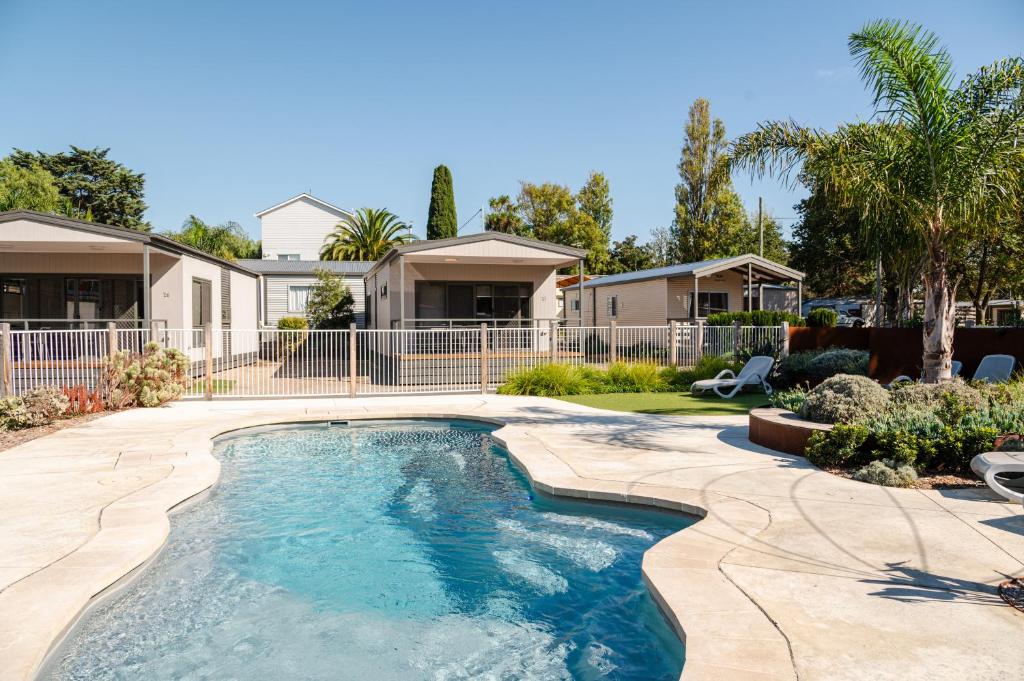 a swimming pool in a yard with houses at Geelong Holiday Park in Geelong