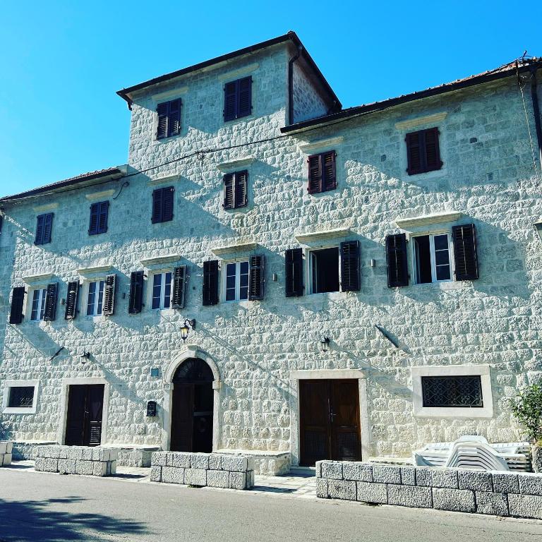 a large stone building with black doors and windows at Villa Old Mariner in Kotor