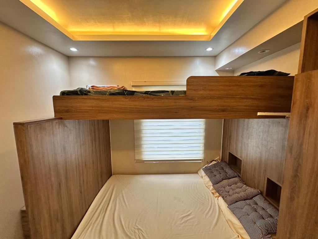 a bedroom with two bunk beds and a window at Cozy Modern Loft Studio in Cubao in Manila