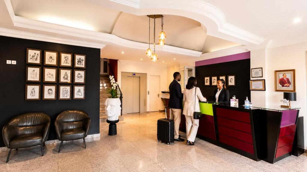 zwei Personen stehen an einem Tresen in einem Salon in der Unterkunft Futuris Hotel in Douala