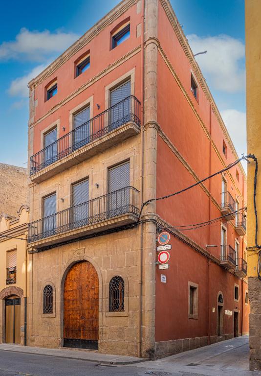 a brick building with a door and a balcony at La Casa del Miracle, hostal in Balaguer