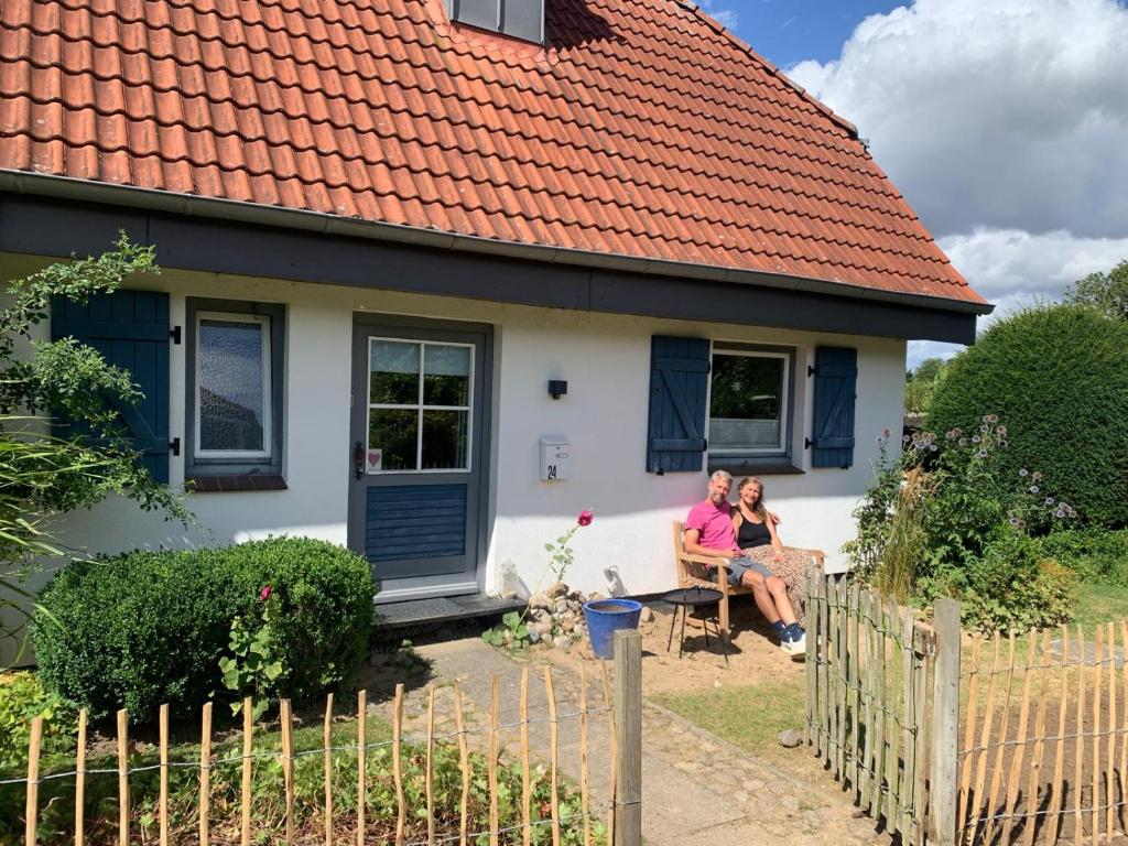 two people sitting on a couch in front of a house at Schleihaus Lorenz mit Feldblick in Boren
