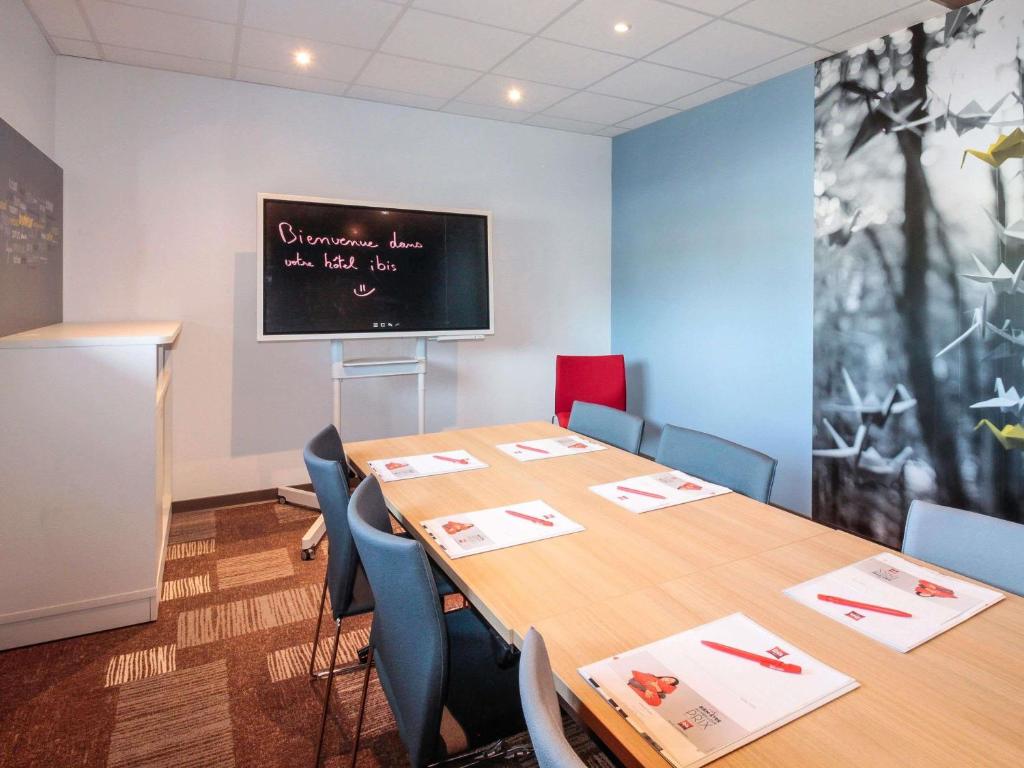 a conference room with a table and a chalkboard on the wall at ibis Cahors in Cahors