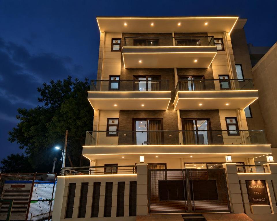 a tall building with lights on it at night at Hotel Retro Folic Near Golf Course Road & Cyber City in Gurgaon