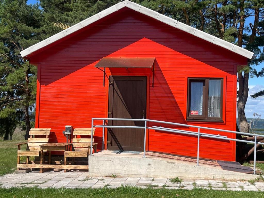 a red shed with a table and a bench at Rāznas ezera namiņš D1 ar elektrisko apkuri in Ragi