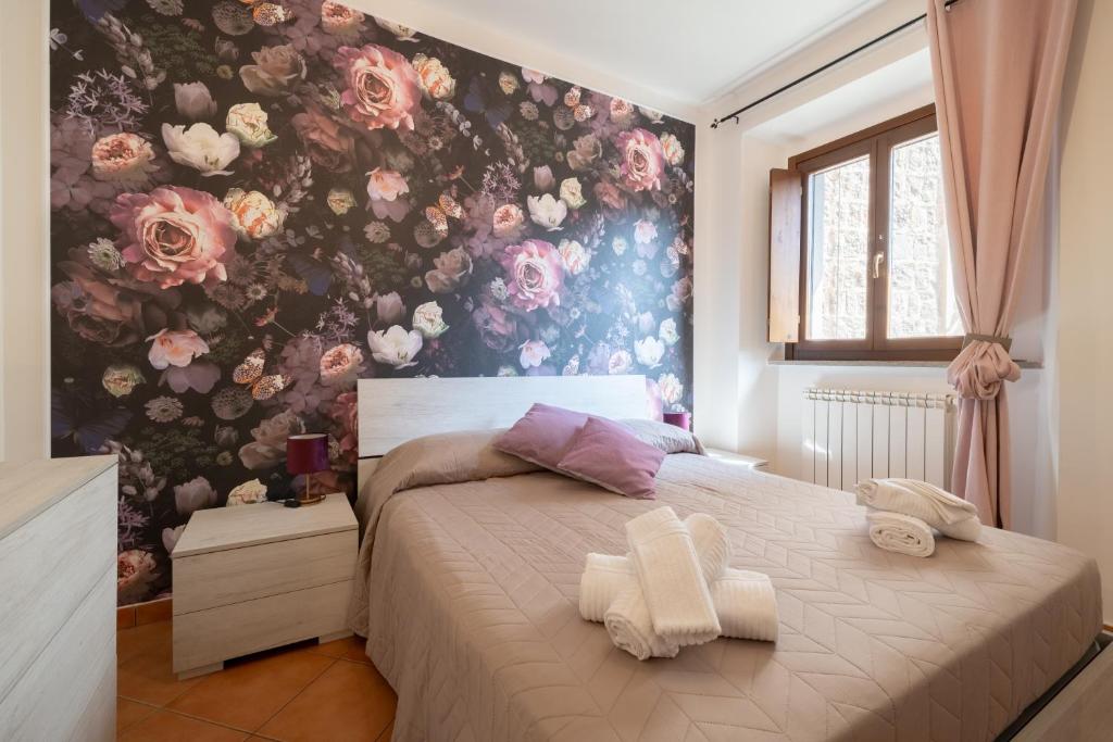 a bedroom with a bed with a floral wall at A Cuor Leggero Home in Viterbo