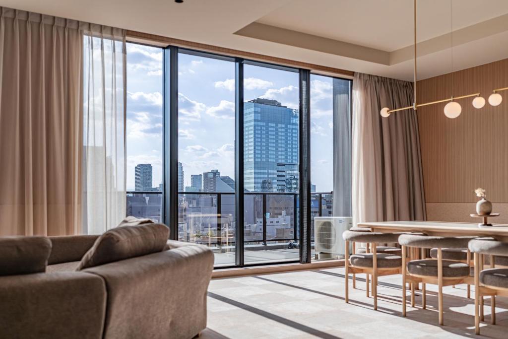 a living room with a table and a large window at Apartment Hotel 11 Shinsaibashi 9 in Osaka