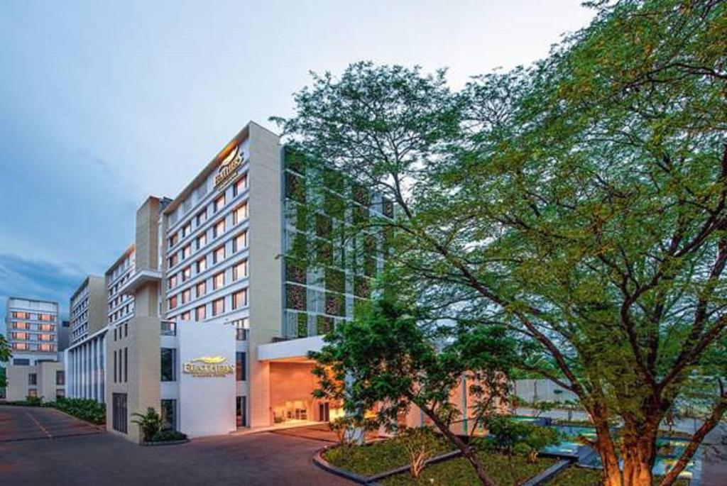 a large building with a tree in front of it at Feathers- A Radha Hotel, Chennai in Chennai