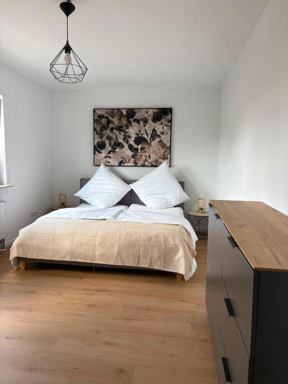 a bedroom with a bed with white walls at WeLiving Apartments in Weinheim