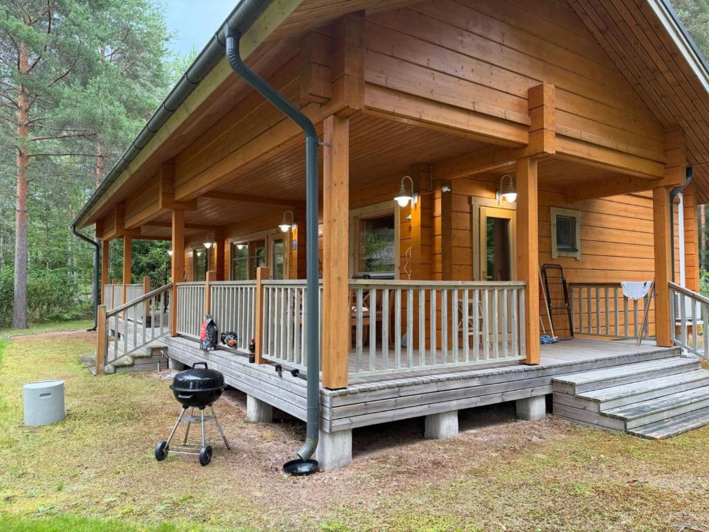 a log cabin with a grill in front of it at Villa Lena in Kouvola