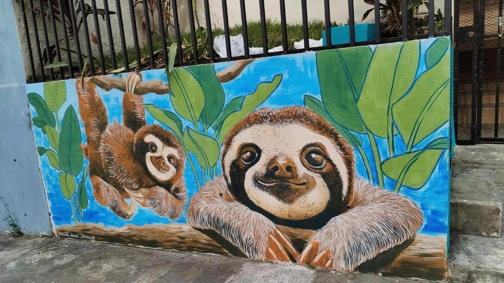 a mural of three sloths on a wall at Casa Escalante Hostel in San José