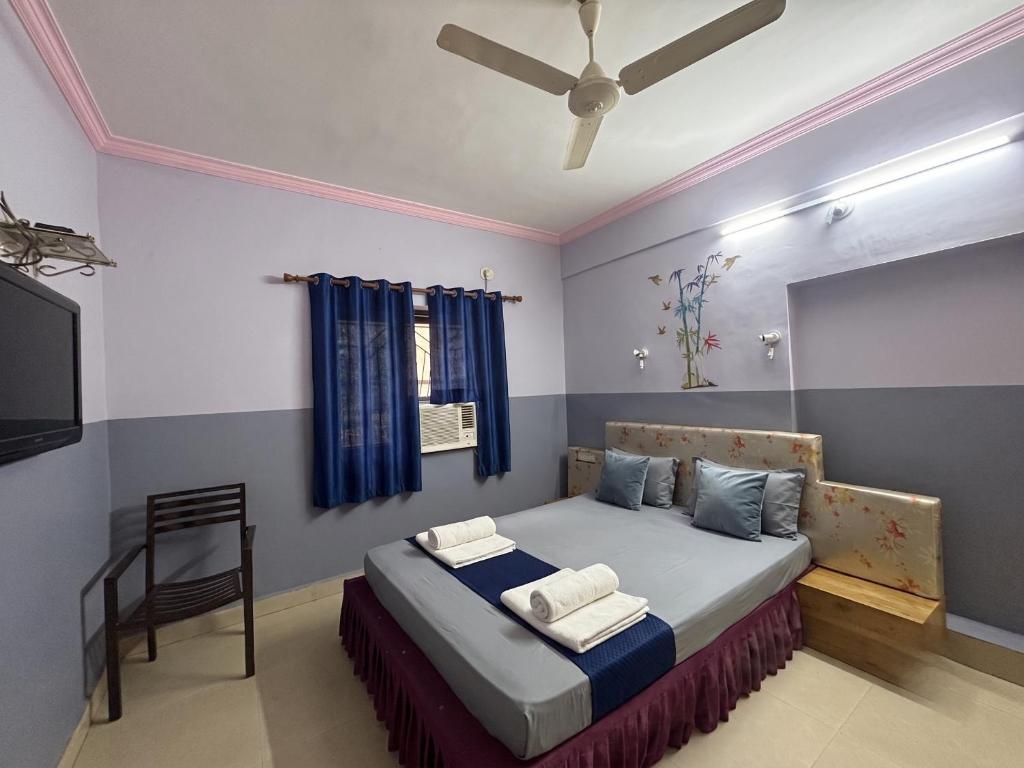 a bedroom with a bed and a tv and a chair at FabHotels Fiora in Pune