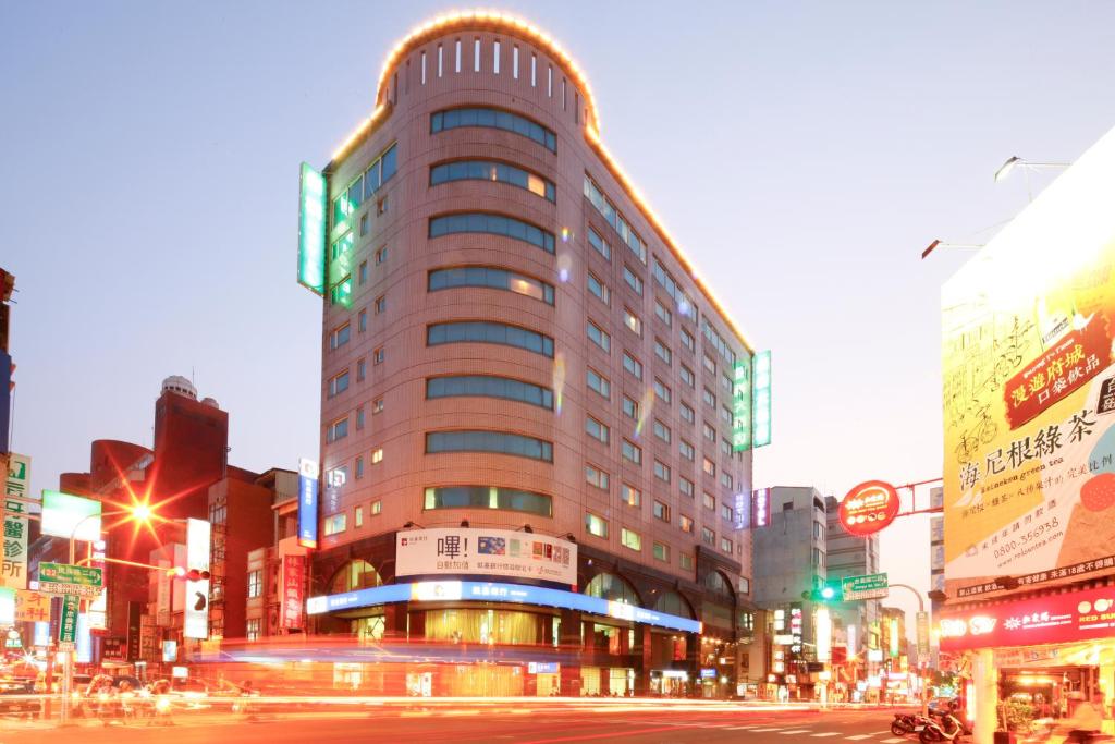 a tall building on a city street at night at Cambridge Tainan Hotel in Tainan