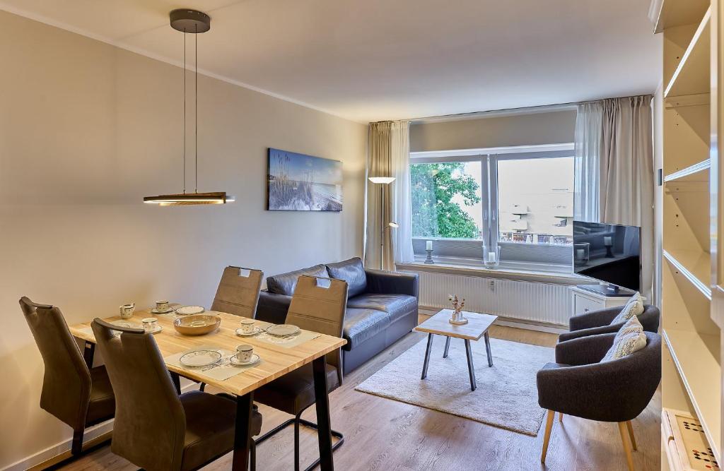 a living room with a table and a blue couch at Haus Schildt, FeWo 1 in Duhnen