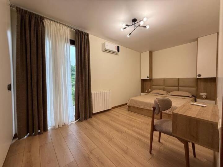 a bedroom with a bed and a table and a window at Black sea batumi in Chakvi