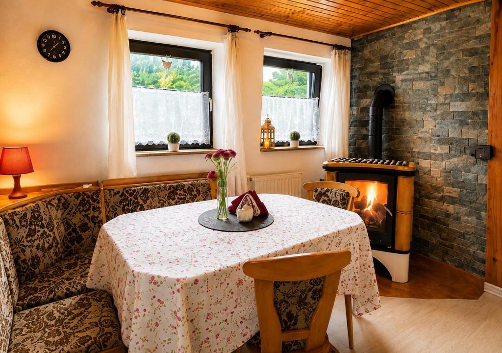 a dining room with a table and a fireplace at U krbu in Jindřichovice