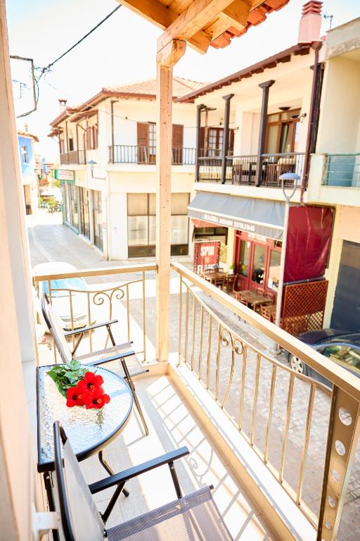a balcony with chairs and a table with a flower on it at Casa di Fava in Agios Nikolaos
