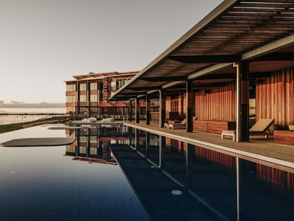 a building with a pool of water in front of it at The Sebel Yarrawonga Silverwoods in Yarrawonga