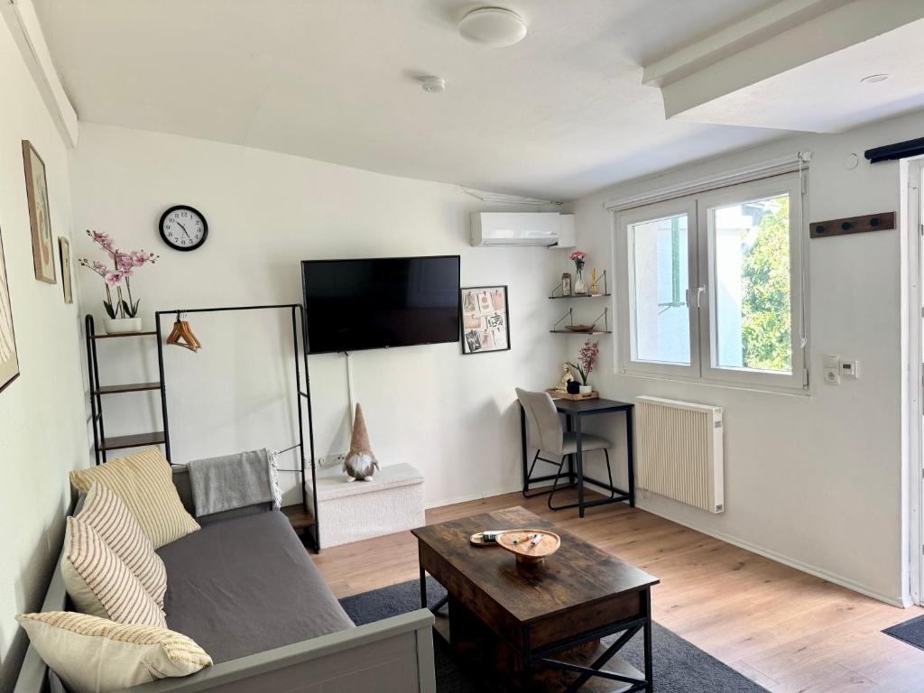a living room with a couch and a table at Mini Apartment mit Garten und Küche in Ilbenstadt