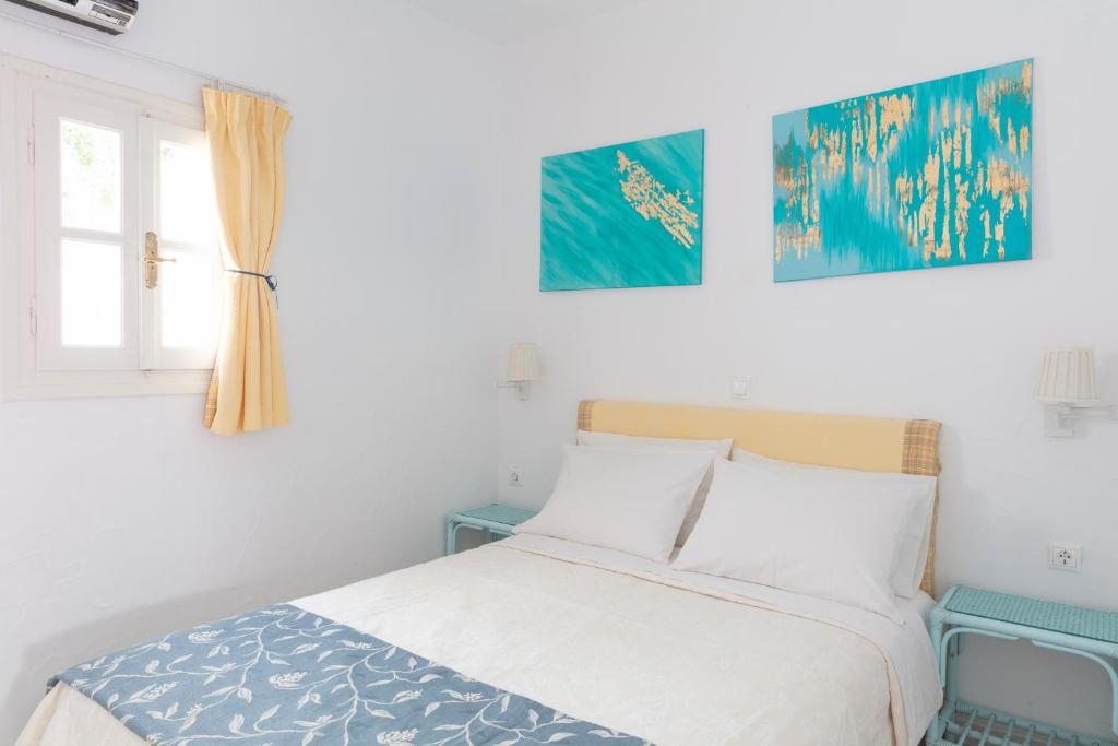 a bedroom with a bed and two pictures on the wall at Ibiscus down town location Myconos in Megali Ammos