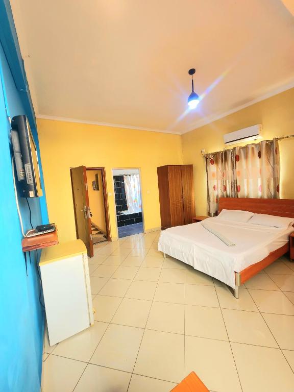 a bedroom with a bed and a flat screen tv at Mimos Hotel in Tete