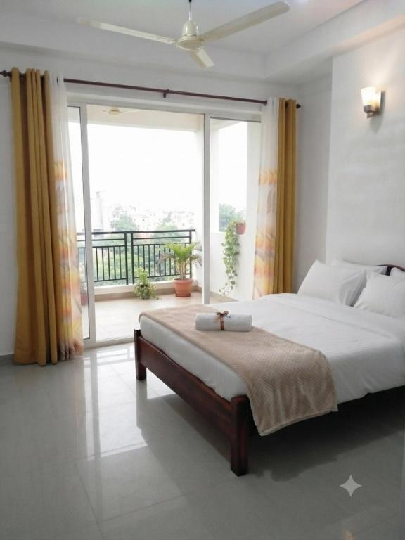 a bedroom with a large bed and a large window at msm diamond villa in Ragama