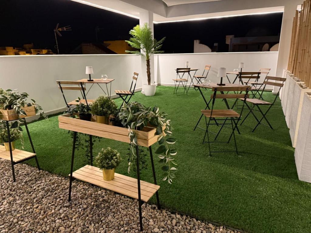 a room with tables and chairs with plants on grass at Apartamentos Alsa in Conil de la Frontera