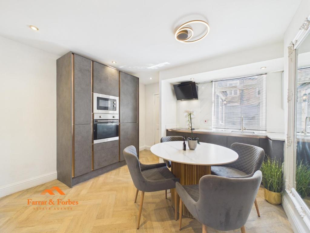 a kitchen and dining room with a table and chairs at Cosy Colne Cottage in Colne