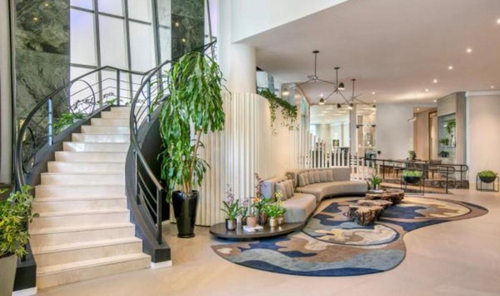 a living room with a staircase with potted plants at Hotel ML Jardim Europa Itaim UH-303 in São Paulo