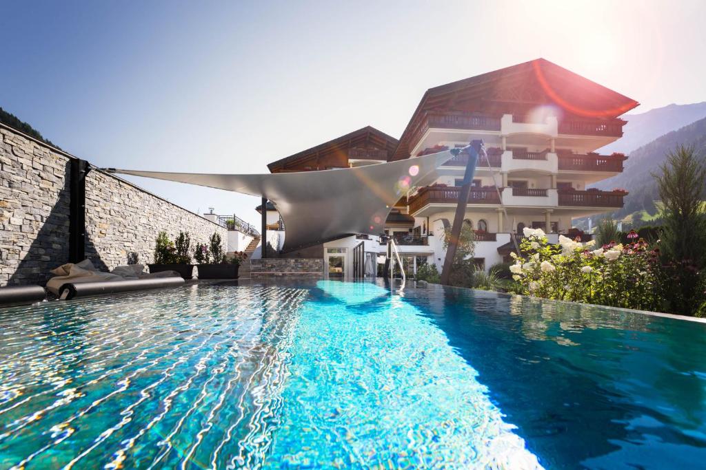 a swimming pool in front of a building at Hotel Stubaierhof in Neustift im Stubaital