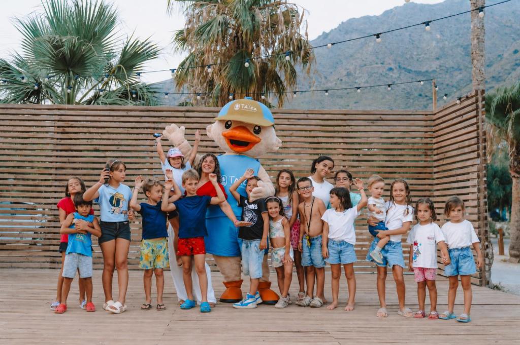 a group of children posing for a picture with a mascot at TAIGA Bassegoda Park in Albanya