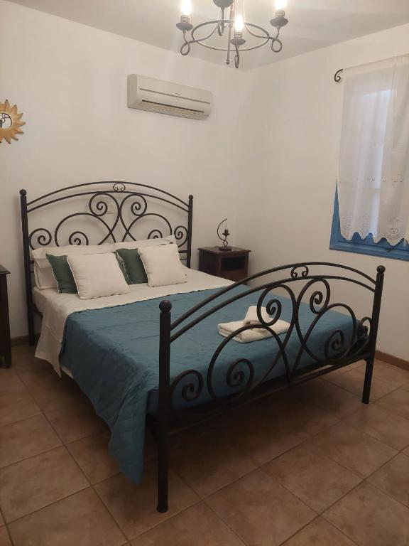 a bedroom with a black bed with a blue blanket at Meraki lipsi apartment in Leipsoi