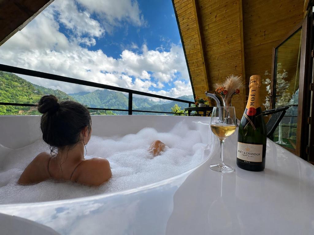 a little girl sitting in a bath tub with a glass of wine at cottage sunrise house merisi in Merisi