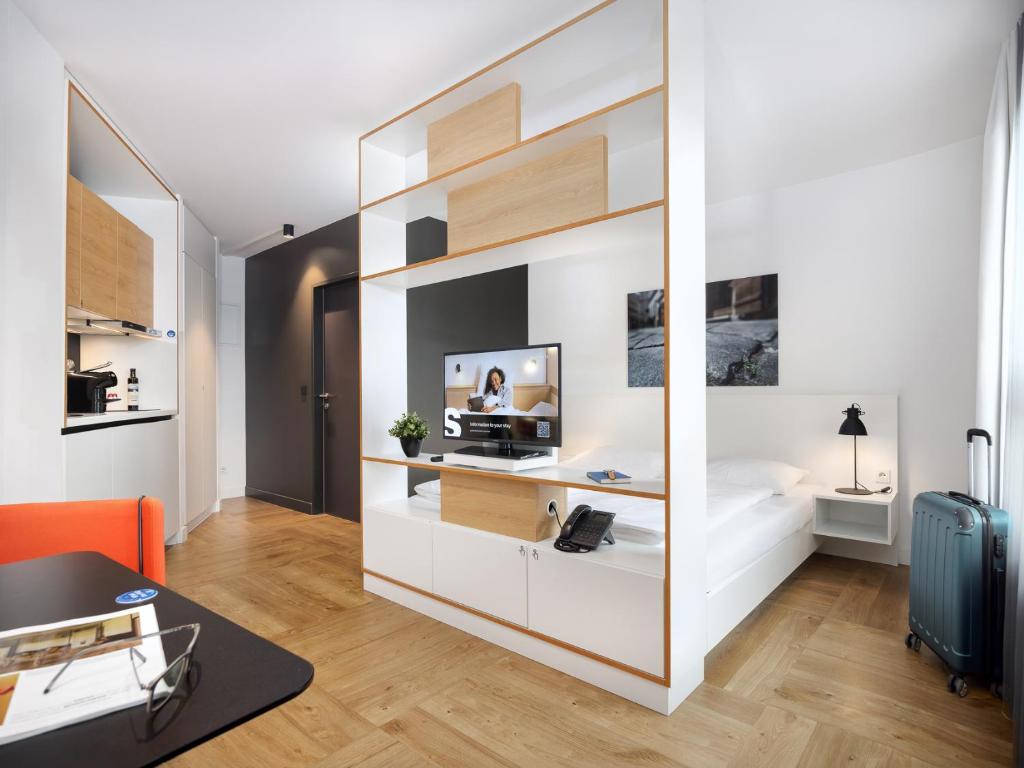 a room with a large white partition with a desk at smartments Wien Hauptbahnhof - Serviced Apartments in Vienna