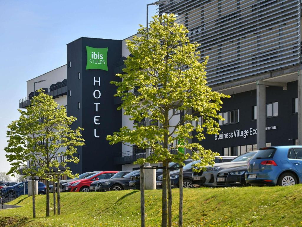 a parking lot with cars parked in front of a building at ibis Styles Namur in Namur