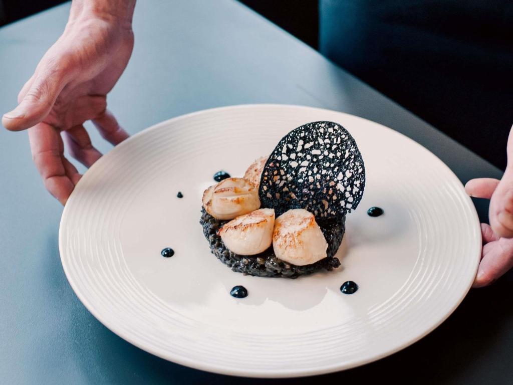 a person holding a plate with a dessert on it at Tribe Carcassonne in Carcassonne