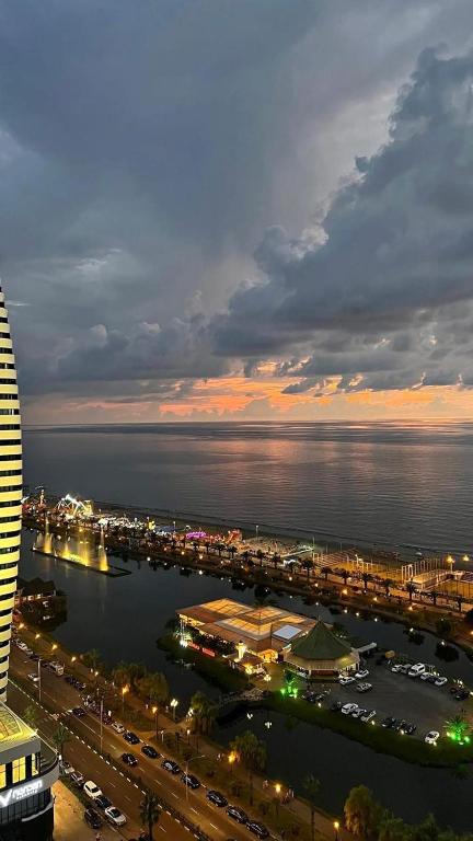 a view of a city with a harbor at night at VELOR Hotel apartment in Batumi