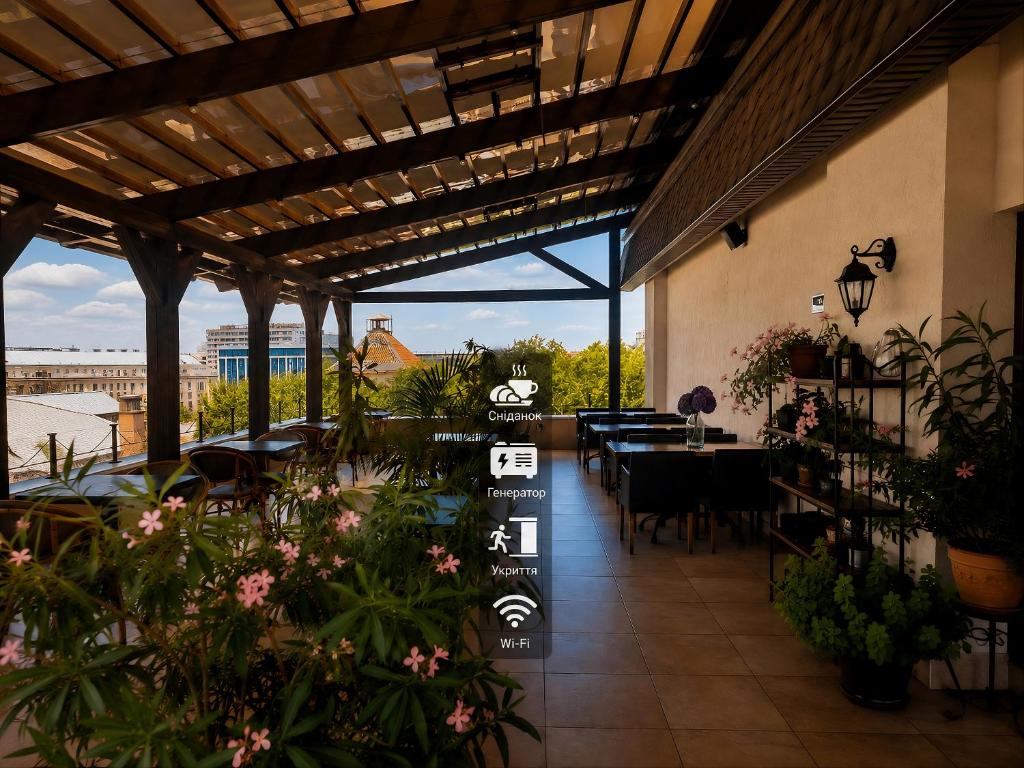 ein Restaurant mit Terrasse, Tischen und Pflanzen in der Unterkunft Ayvazovsky Hotel in Odessa