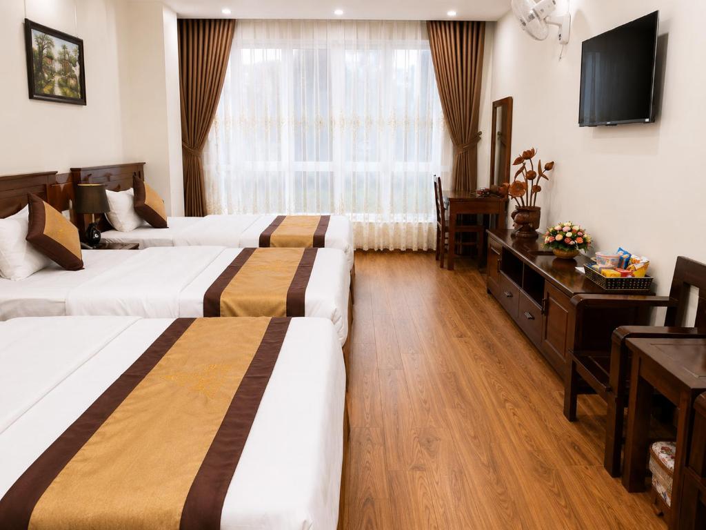 a hotel room with two beds and a television at Mama Cao Bang Hotel in Cao Bằng