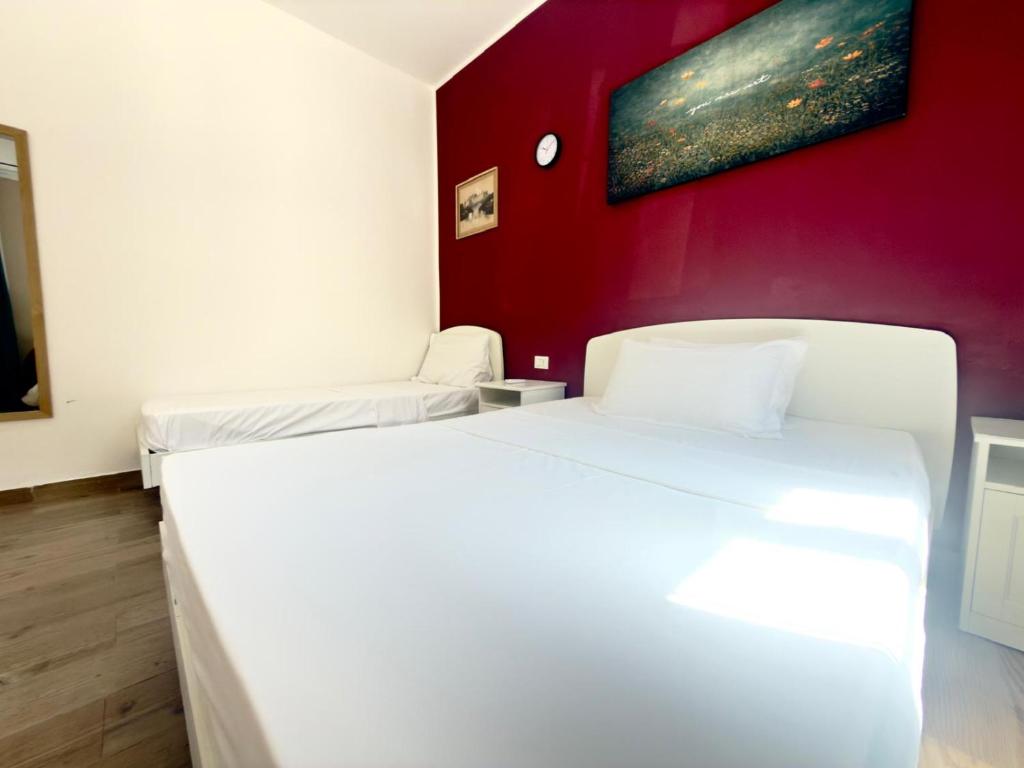 a bedroom with two beds and a red wall at Dream holiday in Mestre